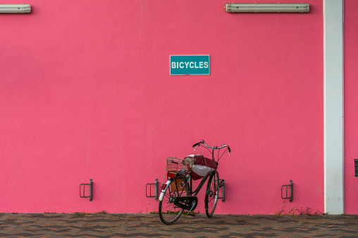 one Bicycle against a pink wall