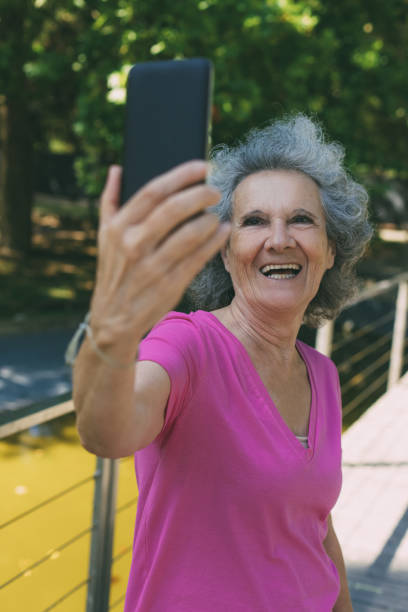 istock Happy laughing old lady chatting through video call 1209836146