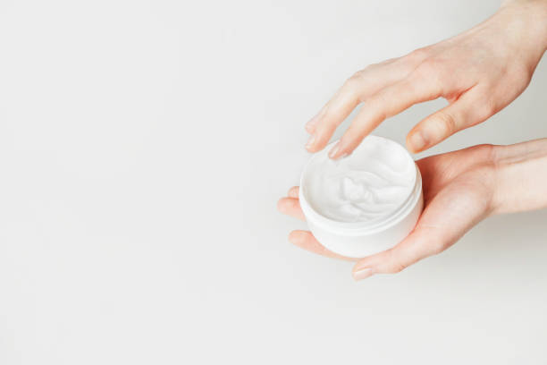 istock Woman hand touch moisturizer white cream in jar. Isolated on white with copy space 1209838803