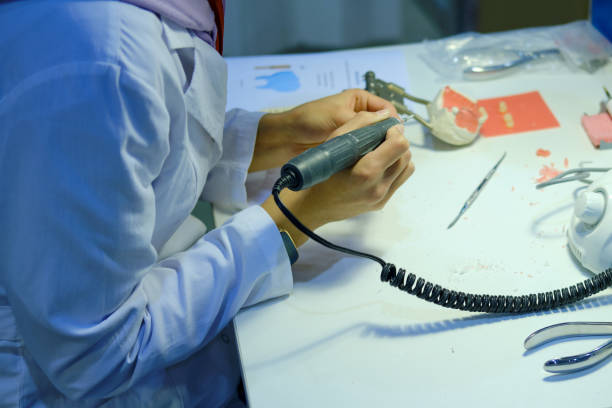 praktikum in einer klinik mit medizinstudenten. praktikantin in derausbildung trainiert die herstellung von zahnersatz. - articulator stock-fotos und bilder