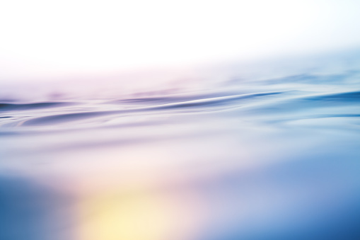 Close-up of rippled sea surface. Background with colorful light leaks.