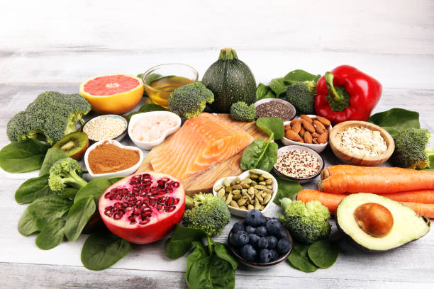 istock Healthy food clean eating selection: fish, fruit, vegetable, cereal, leaf vegetable on rustic background 1209839630