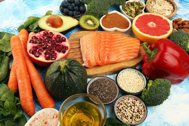istock Healthy food clean eating selection: fish, fruit, vegetable, cereal, leaf vegetable on rustic background 1209840531
