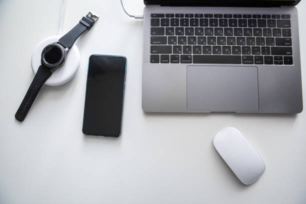 istock laptop with phone computer mouse and smart watch charging on wireless charger 1209840582