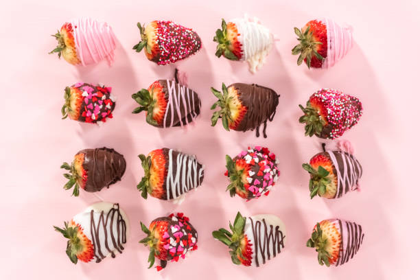 Variety of chocolate dipped strawberries on a pink background. Flat lay. Variety of chocolate dipped strawberries on a pink background. chocolate covered strawberries stock pictures, royalty-free photos & images