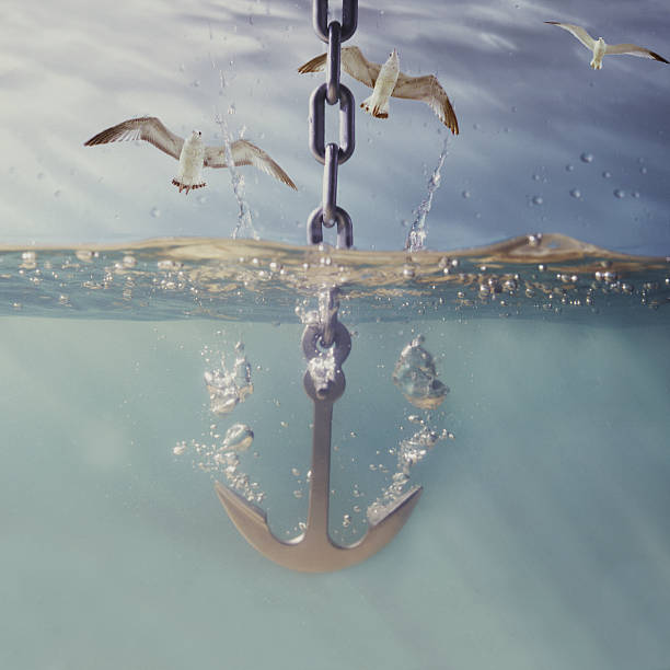 anchor dropping into water stock photo