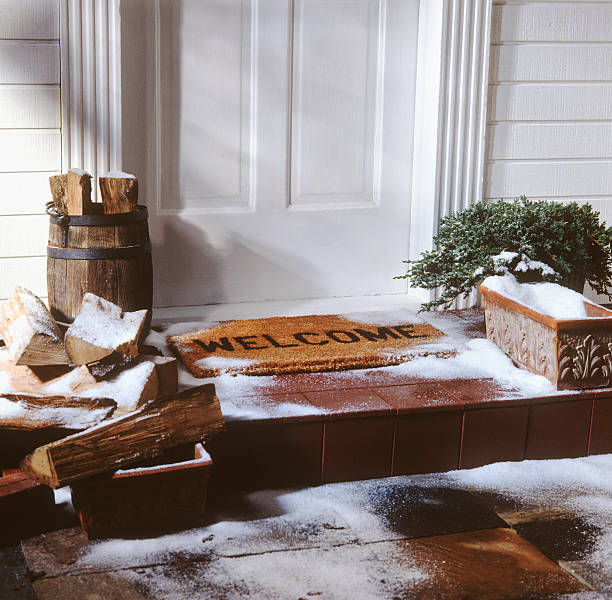 door of house with welcome mat in winter stock photo