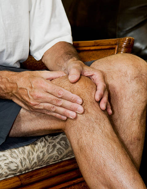 man massaging knee stock photo