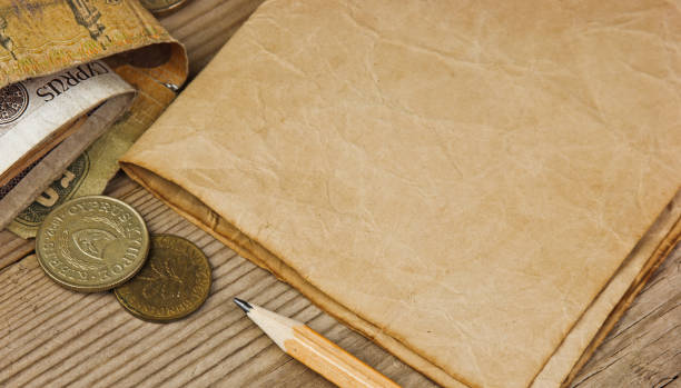 istock Old notes and coins and pencil on a wooden table 1209846921