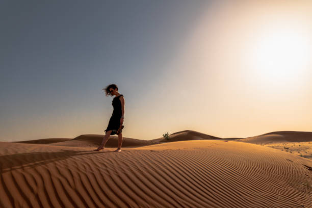 istock Woman in the desert before sunset 1209847063