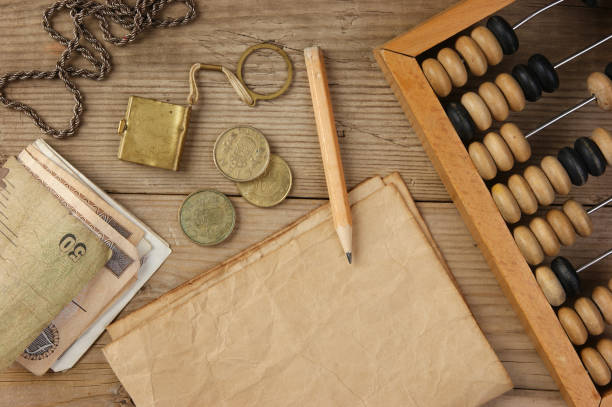 istock Old notes and coins and abacus on a wooden table 1209847147