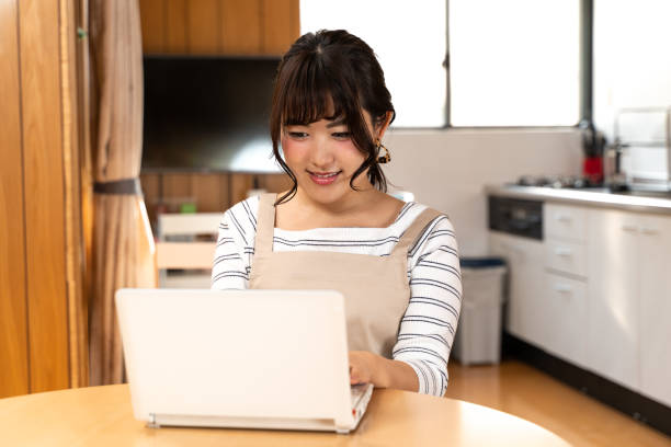 istock Young housewife using personal computer at home 1209847781