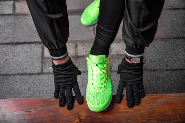 istock Man tying running shoes in urban park. 1209848268