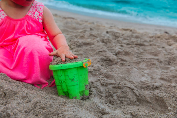 istock little girl playing with sand on beach vacation 1209848662