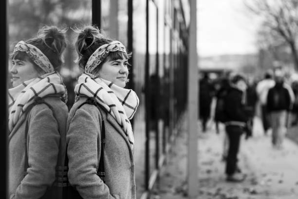 Vienna, Austria - November 29, 2019: Young woman watching Earth-strike demonstration from a sidewalk