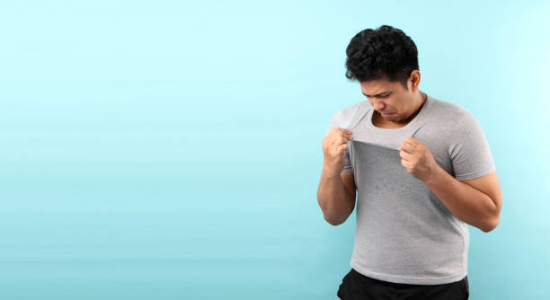 istock Asia Man sweating excessively smelling bad isolated on bluebackground in studio With copy space. 1209849177