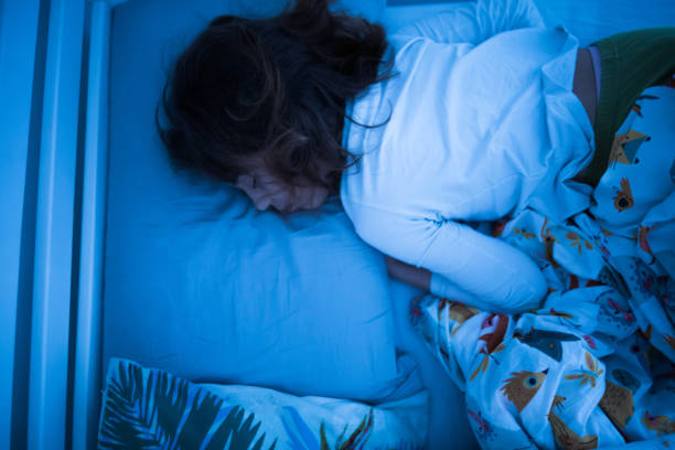 istock Small 11 year old girl sleeping in bed on a stomach. 1209849943
