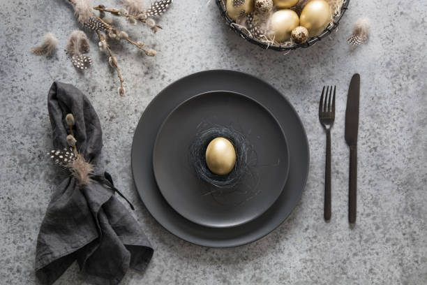 istock Easter table setting with black and golden decor on grey. Top view. 1209850497