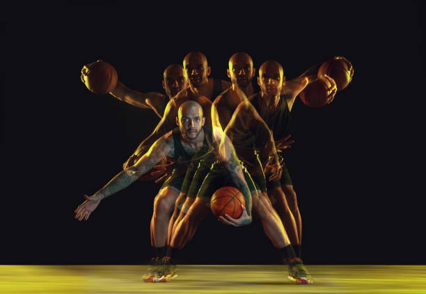 istock Young basketball player training on dark studio background in neon, strobe light 1209850697