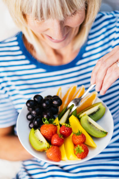 istock Attractive senior woman with fruit lunch 1209851441