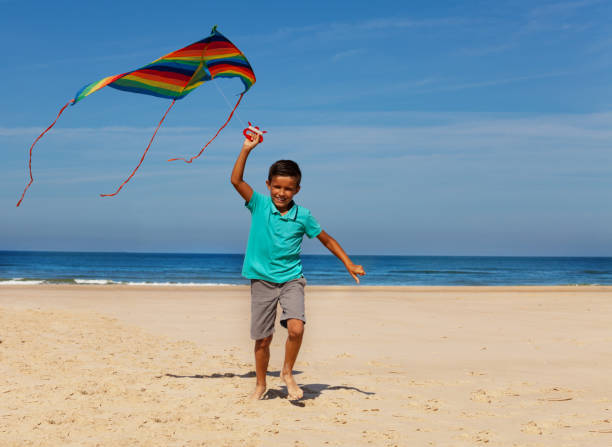 istock Happy little boy run with color stripped kite 1209851661