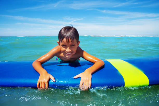 istock Little surfer board swim in sea hold surfboard 1209851665