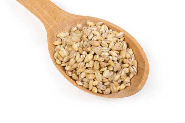 istock Raw pearl barley in wooden spoon on a white background 1209851715