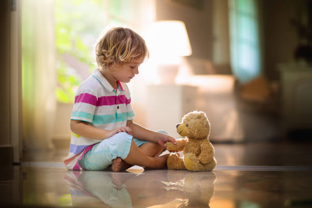 istock Child playing with teddy bear. Kid and toy at home 1209851844