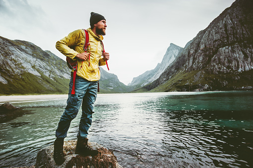 Man backpacker walking on Horseid beach in Norway Travel lifestyle wanderlust concept adventure outdoor summer vacations wild nature