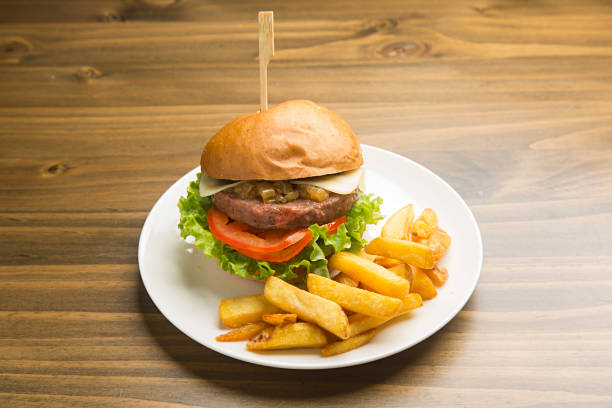 istock Beef burger with caramelized onion and french fries. 1209853410
