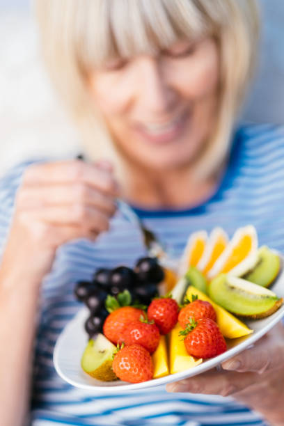 istock Attractive senior woman with fruit lunch 1209854198