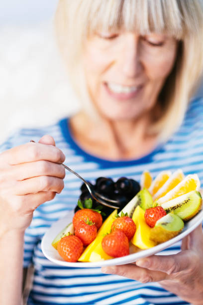 istock Attractive senior woman with fruit lunch 1209855806