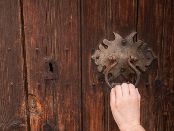 istock Black iron knocker on retro old wooden doo 1209856688