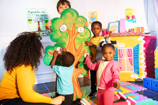 dzieci uczą się alfabetu, umieszczając litery na drzewie - developmental zdjęcia i obrazy z banku zdjęć