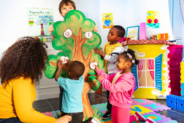 istock Little kids in nursery put letters on the tree 1209856703