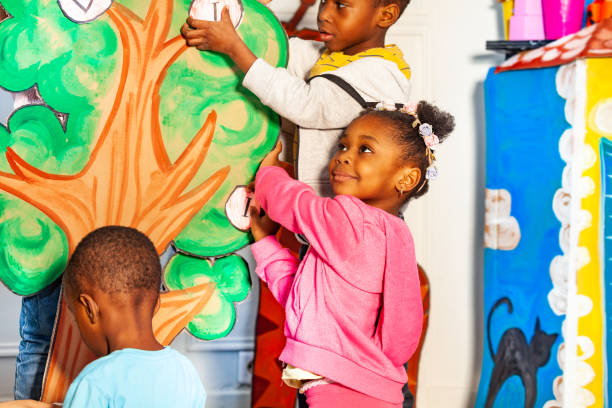 istock Group of kids put letters on the tree in nursery 1209856767