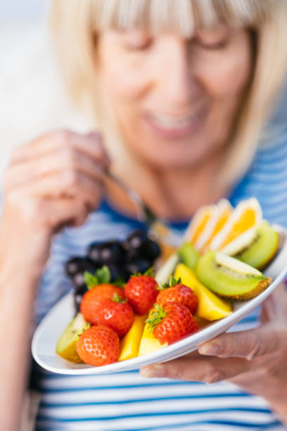 istock Attractive senior woman with fruit lunch 1209857124