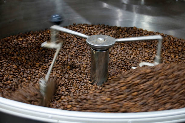 istock The freshly roasted coffee beans from a large coffee roaster being poured into the cooling cylinder. Motion blur on the beans. 1209857392