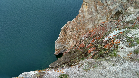 A high rocky coastline a cliff in the sea a lake and fog over the water