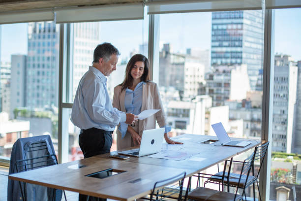 istock Two business workers discuss a project in open pan coworking offices, Buenos Aires 1209859809