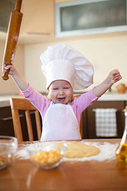 istock Little girl makes dough on kitchen with rolling pin 120986205