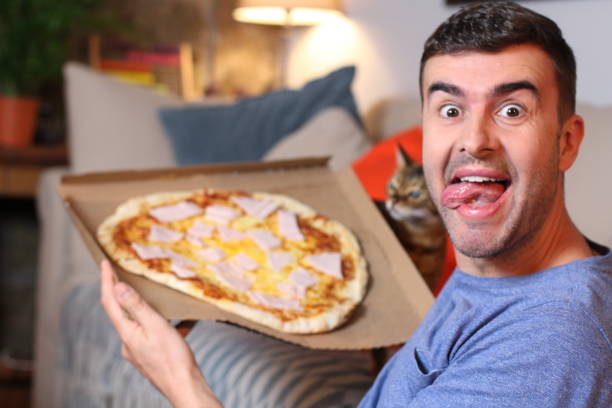 istock Cheerful young man holding a pizza 1209862281