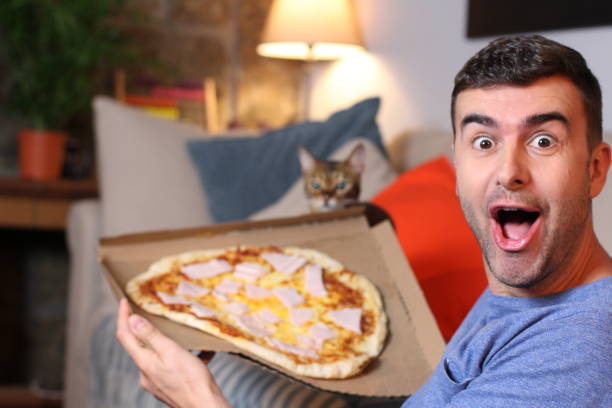 istock Enthusiastic man enjoying pizza at home 1209862293