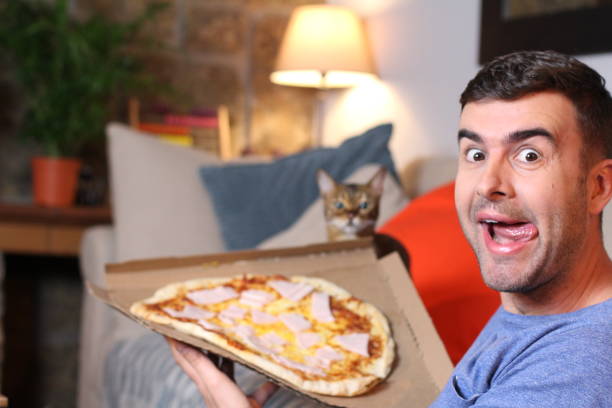 istock Enthusiastic man enjoying pizza at home 1209862303