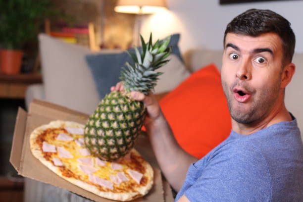 istock Surprised man mixing pizza and pineapple 1209862304