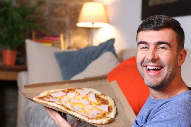 istock Cheerful young man holding a pizza 1209862317