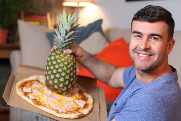 istock Man loving the mix between pizza and pineapple 1209862346