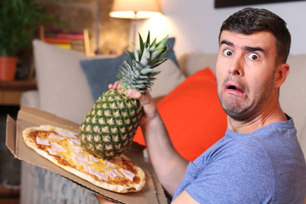 istock Funny man holding pineapple and pizza 1209862378