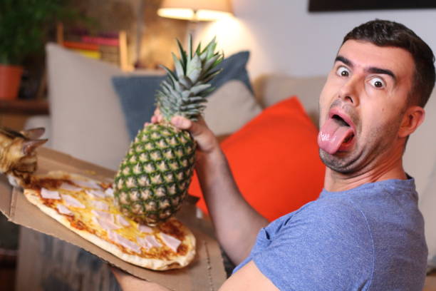 istock Man against mixing pizza and pineapple 1209862386