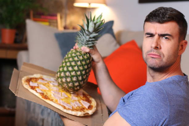 istock Funny man holding pineapple and pizza 1209862401